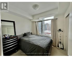 A bedroom with a large bed and a mirror on the wall.