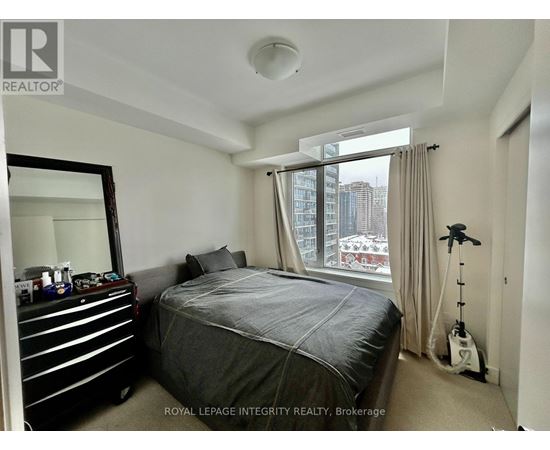 A bedroom with a large bed and a mirror on the wall.
