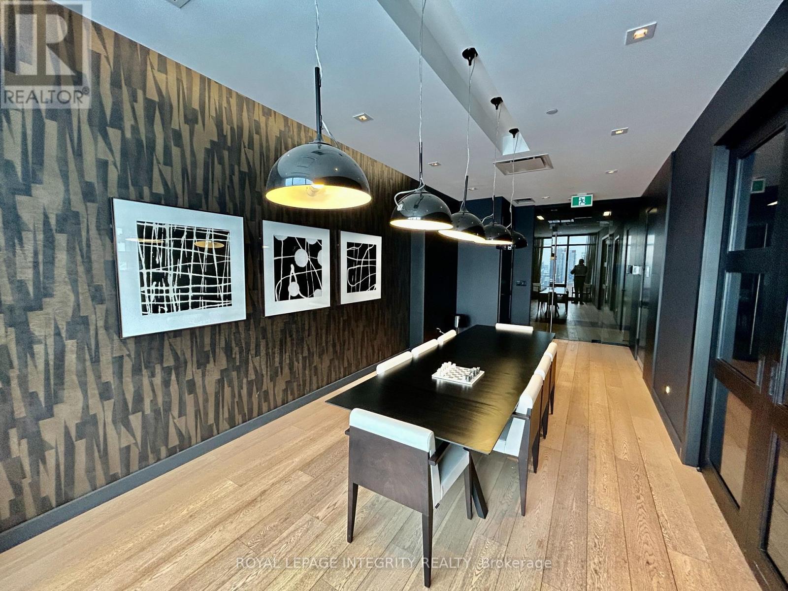 A modern dining room with a wooden table and chairs.