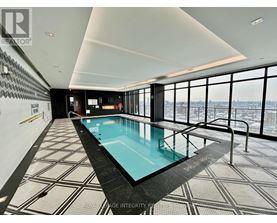 A swimming pool in a room with a view of the city.