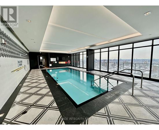 A swimming pool in a room with a view of the city.