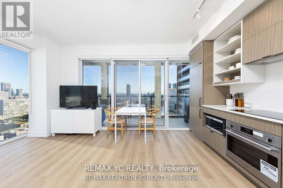 A modern kitchen with a dining table and chairs in front of a large window.