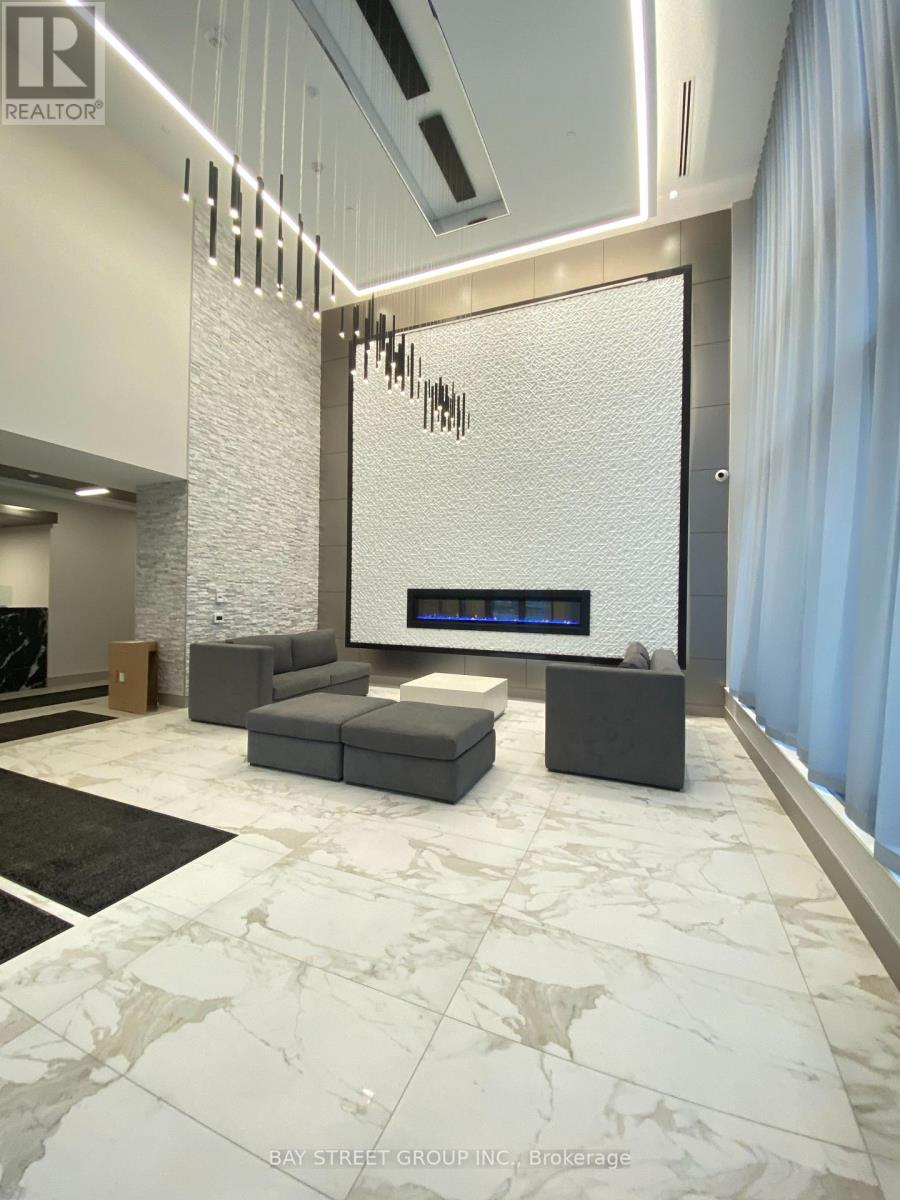 A modern living room with a white marble floor and a large grey sofa.