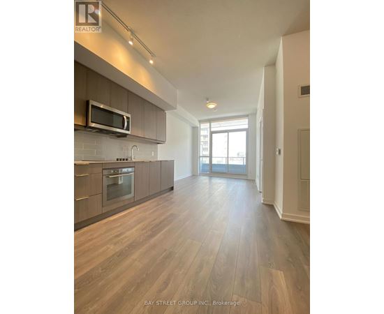 A spacious kitchen with wooden flooring and a modern design.