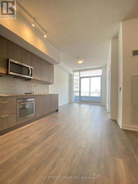 A spacious kitchen with wooden flooring and a modern design.