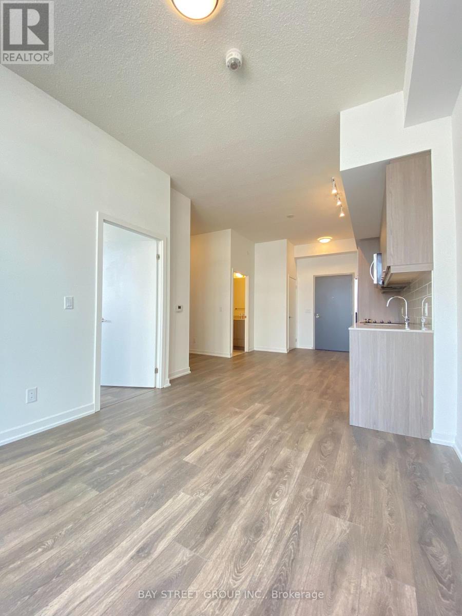 A spacious room with wooden flooring and white walls.