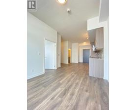 A spacious room with wooden flooring and white walls.