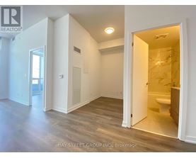 A realtor photo of a white room with a bathroom visible through the door.