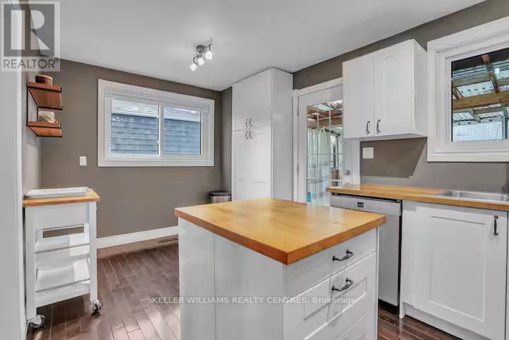 A kitchen with white cabinets and a wooden island.