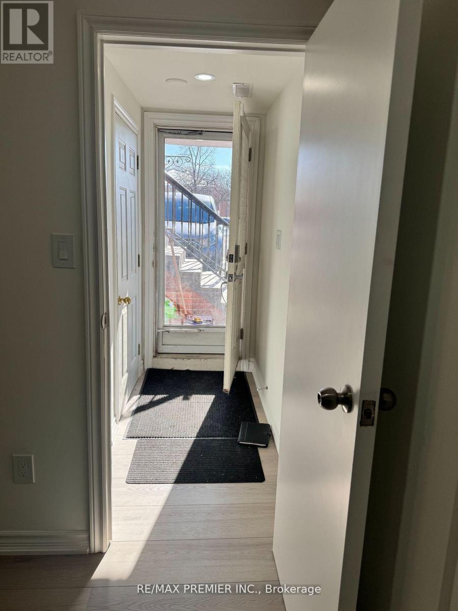 A hallway with a black mat on the floor leading to a door.