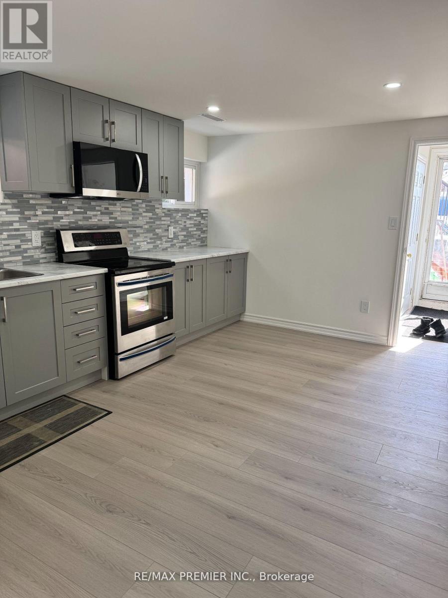 A kitchen with a grey cabinet and a black microwave.