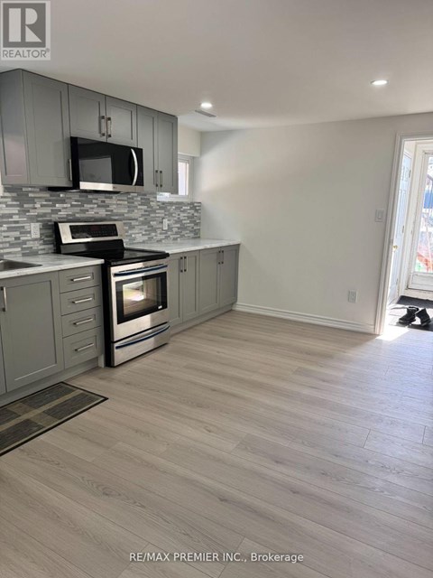 A kitchen with a grey cabinet and a black microwave.