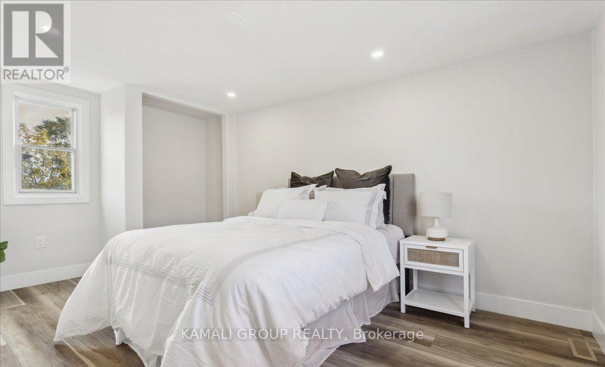 A bedroom with a large bed and a nightstand.