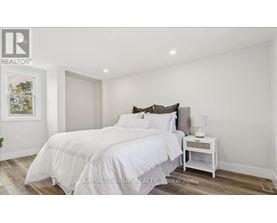 A bedroom with a large bed and a nightstand.