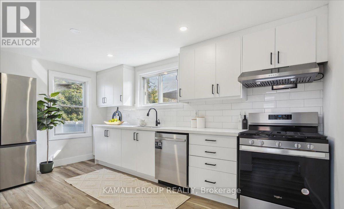 A modern kitchen with white cabinets and stainless steel appliances.