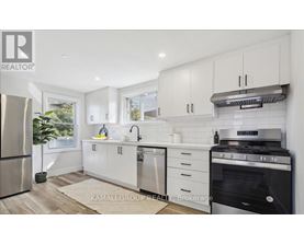 A modern kitchen with white cabinets and stainless steel appliances.