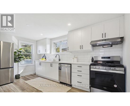 A modern kitchen with white cabinets and stainless steel appliances.