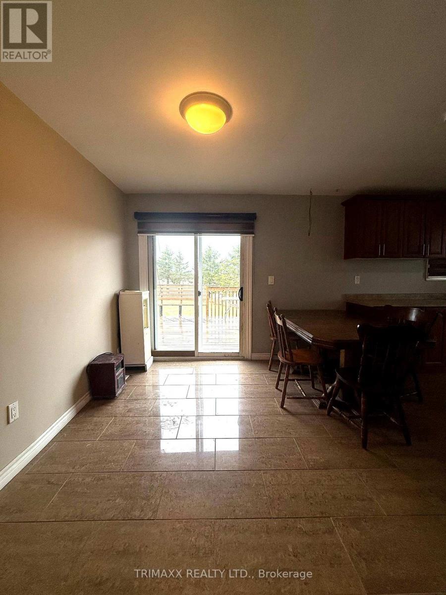 A room with brown tiled flooring and a table with chairs.