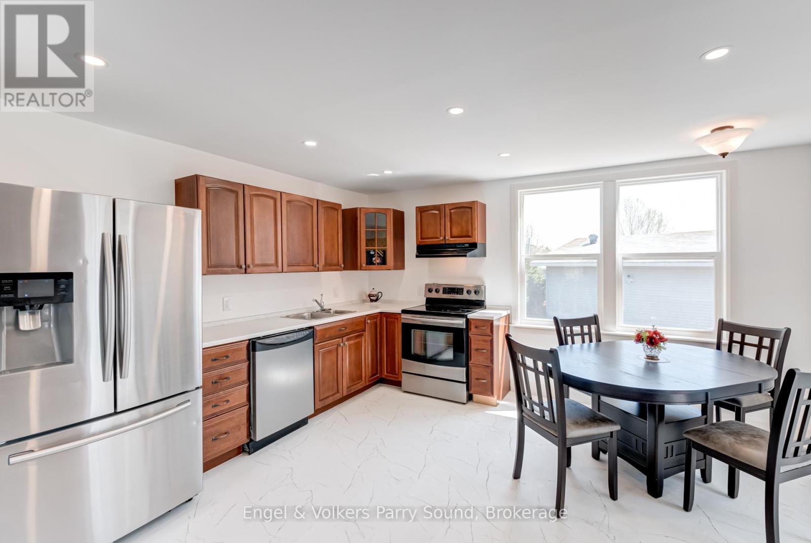 A kitchen with a table and chairs in front of a window.