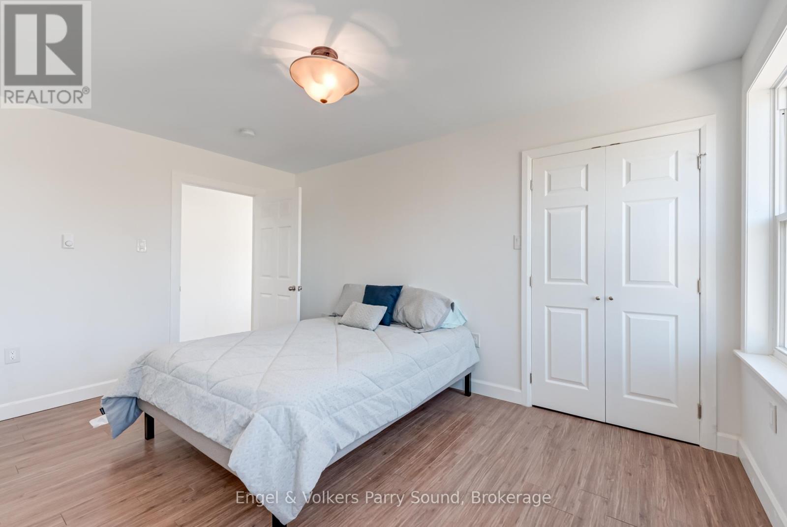 A bedroom with a bed, two pillows, and a lamp.