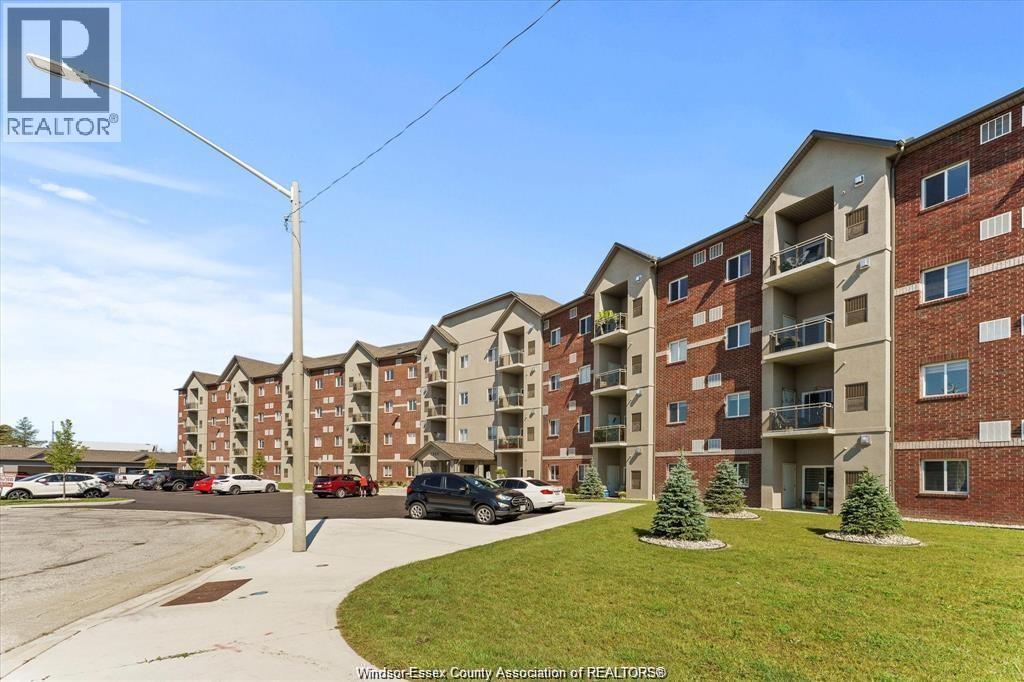 A large apartment complex with a parking lot in front.