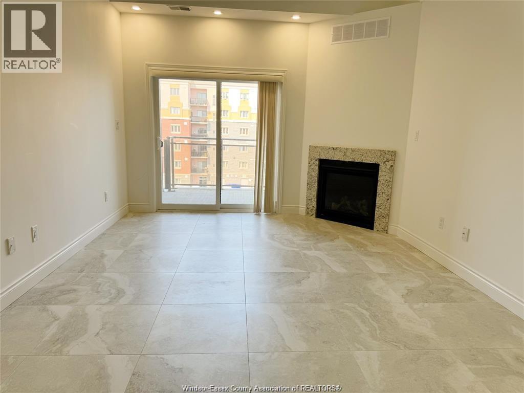 A spacious living room with a fireplace and a view of a building outside through the glass door.