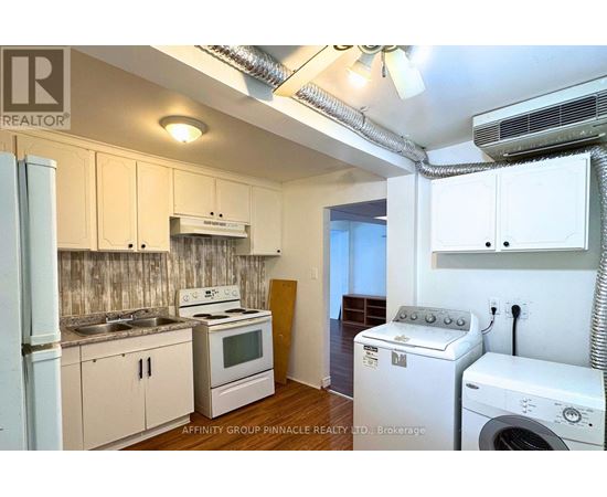 A small kitchen with a washing machine and dryer in it.