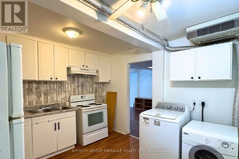 A small kitchen with a washing machine and dryer in it.