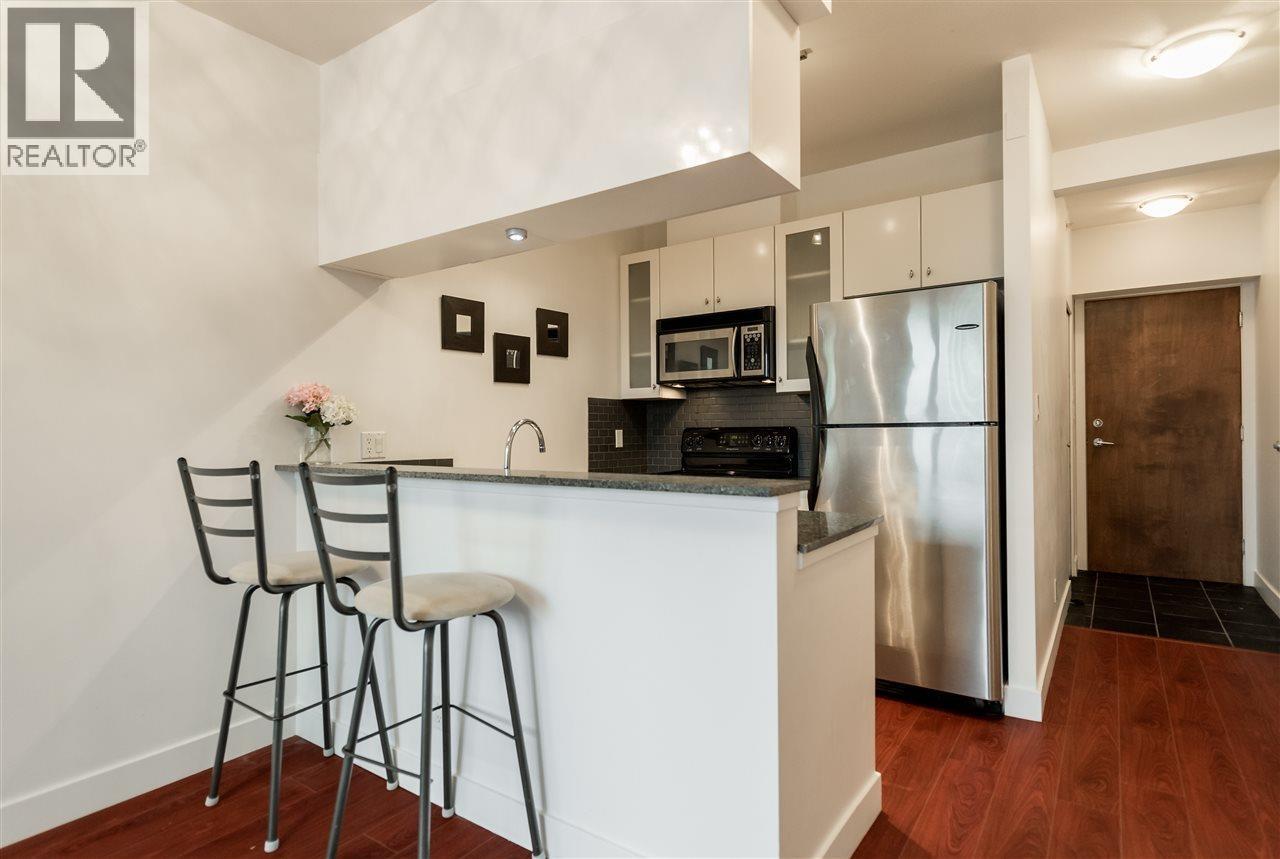 A kitchen with a white counter and a refrigerator.