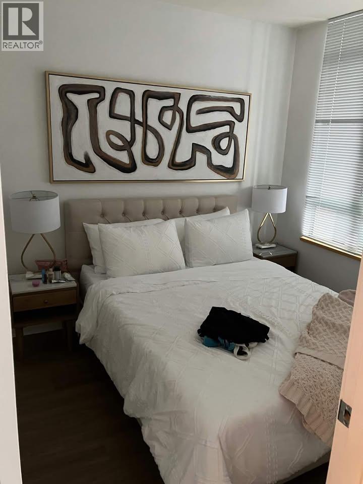 A bedroom with a large bed and a large abstract painting above it.