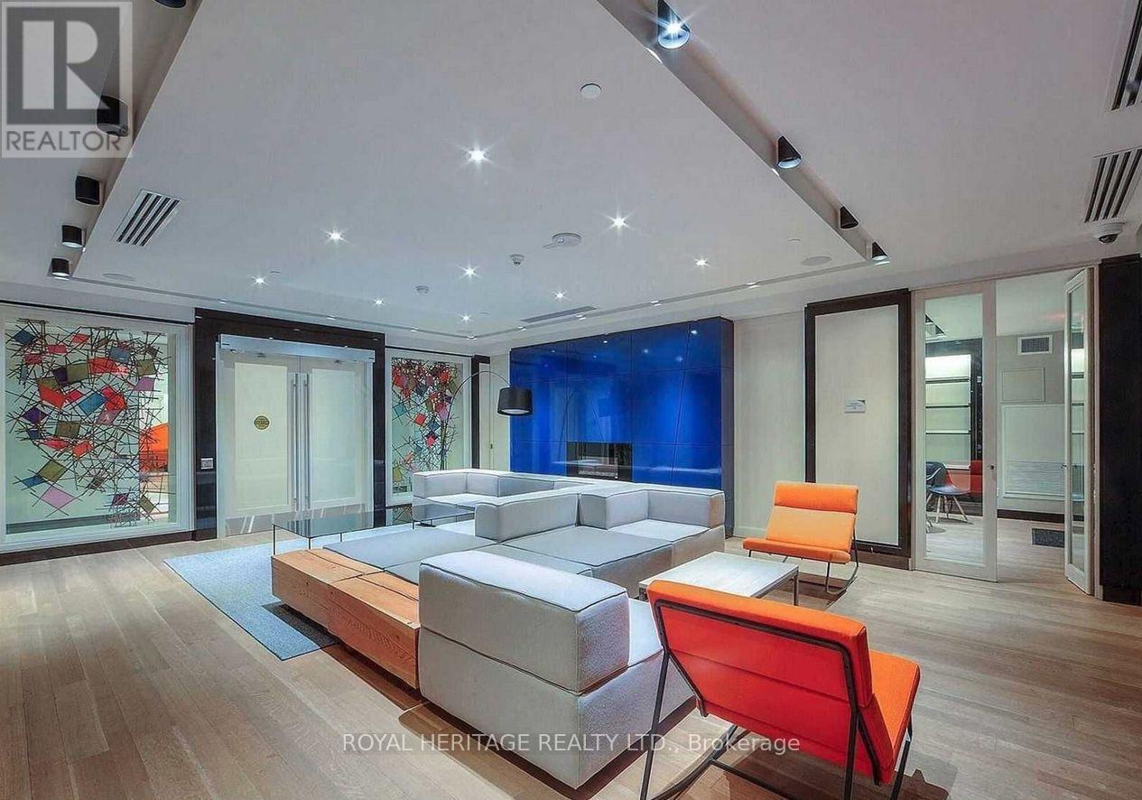 A modern living room with a white sofa and a red chair.