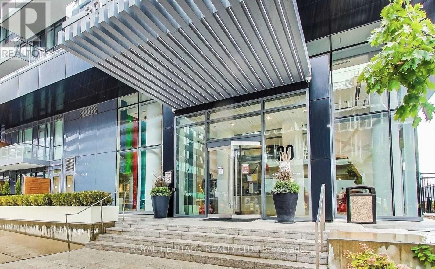 The front of a building with a glass facade and a metal awning.