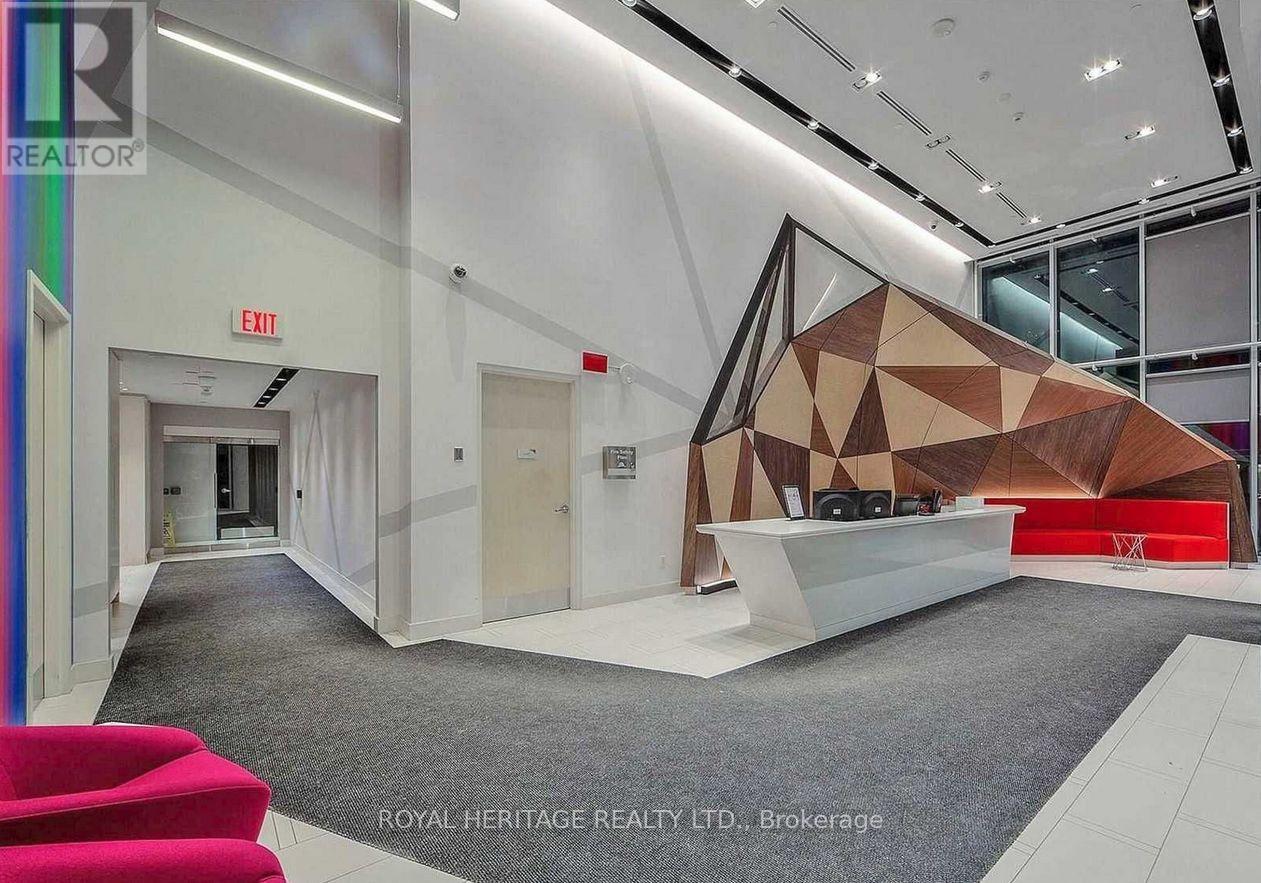 A modern office space with a geometric wall design and a red seating area.