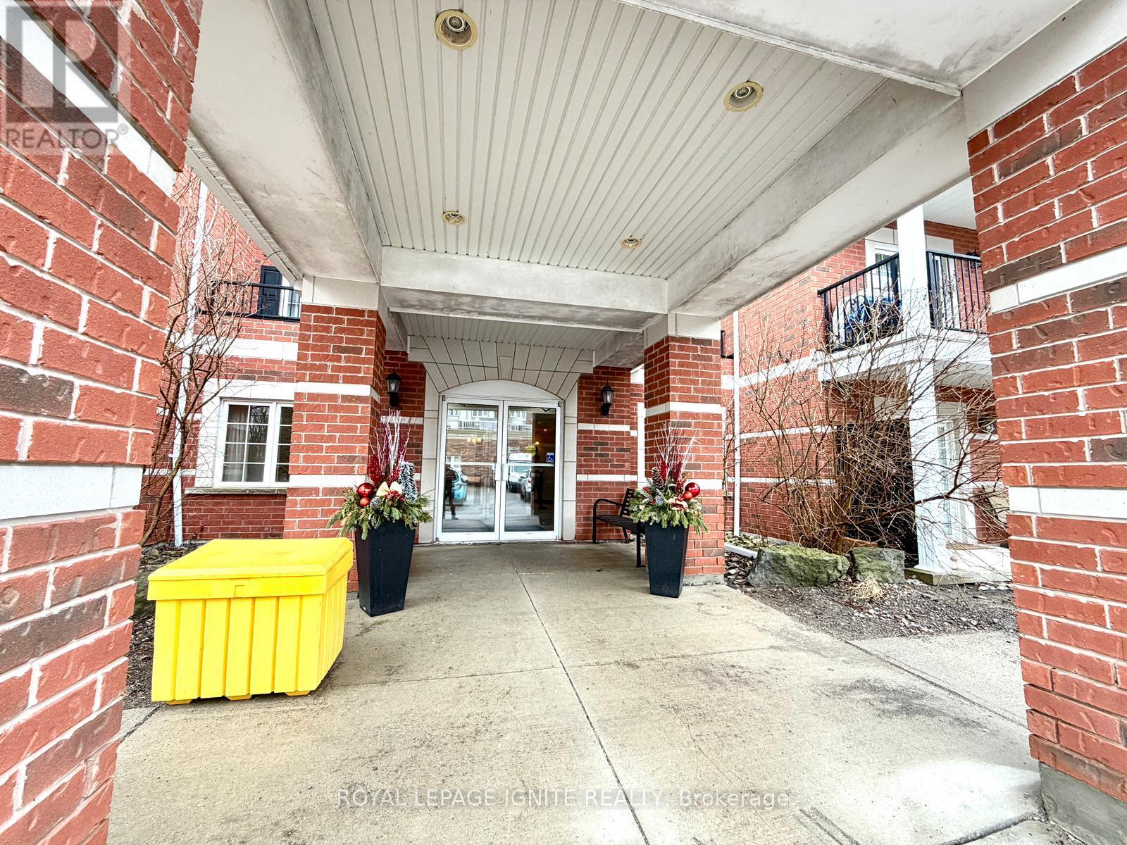A red brick building with a white roof and a yellow planter box.