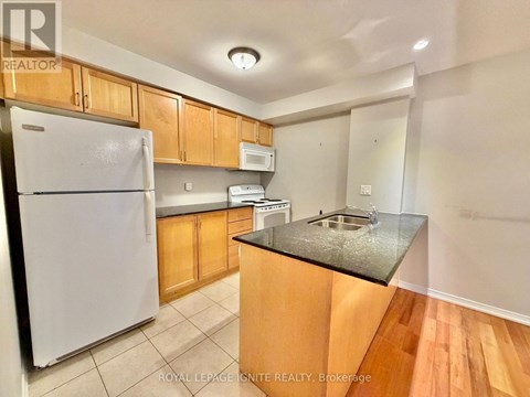 A kitchen with wooden cabinets and a white fridge.