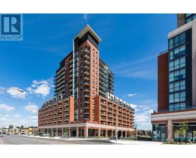 A tall building with a glass facade is situated next to a shorter building with a brick facade.