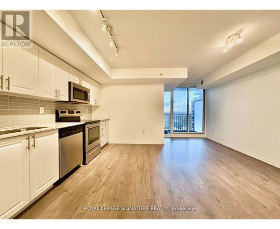 A kitchen with white cabinets and a black counter top.