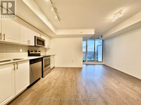 A kitchen with white cabinets and a black counter top.