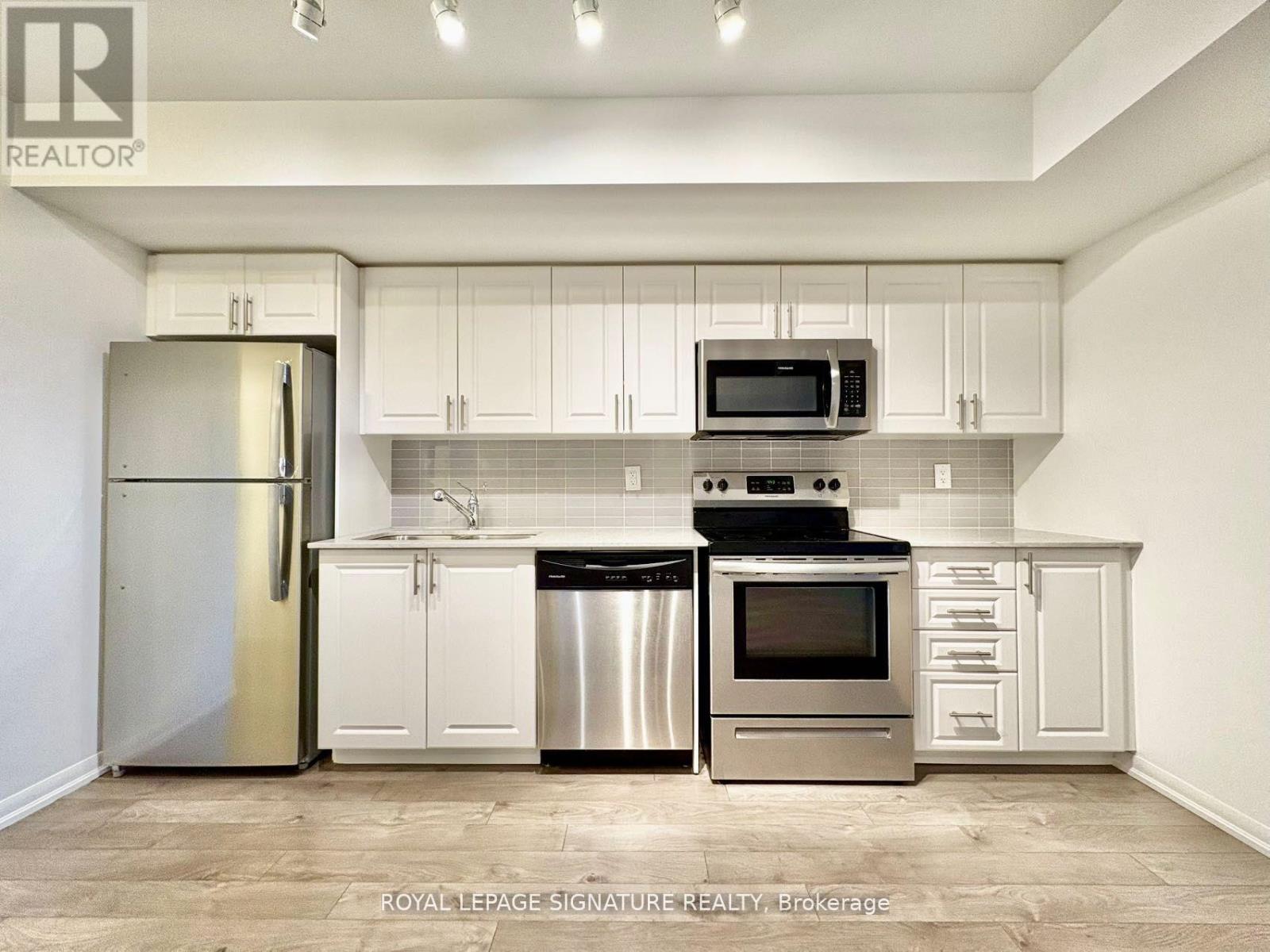 A kitchen with white cabinets and stainless steel appliances.