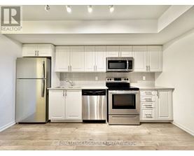 A kitchen with white cabinets and stainless steel appliances.