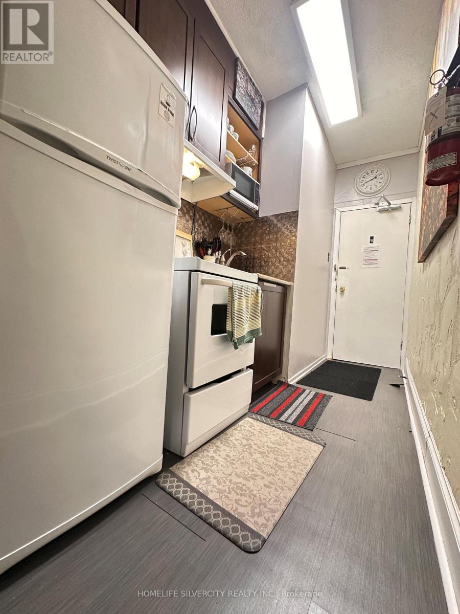 A kitchen with a refrigerator and a door.