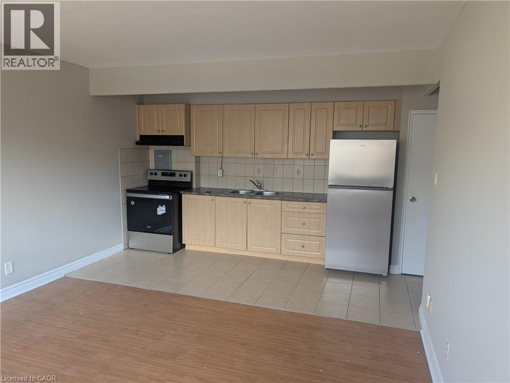 A kitchen with wooden cabinets and a refrigerator.