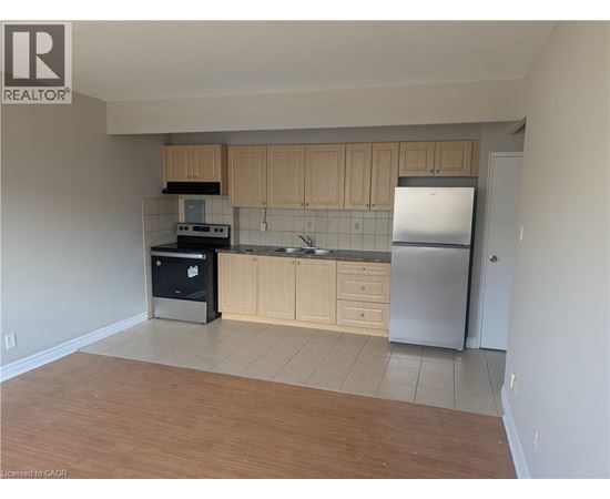 A kitchen with wooden cabinets and a refrigerator.