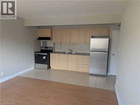 A kitchen with wooden cabinets and a refrigerator.
