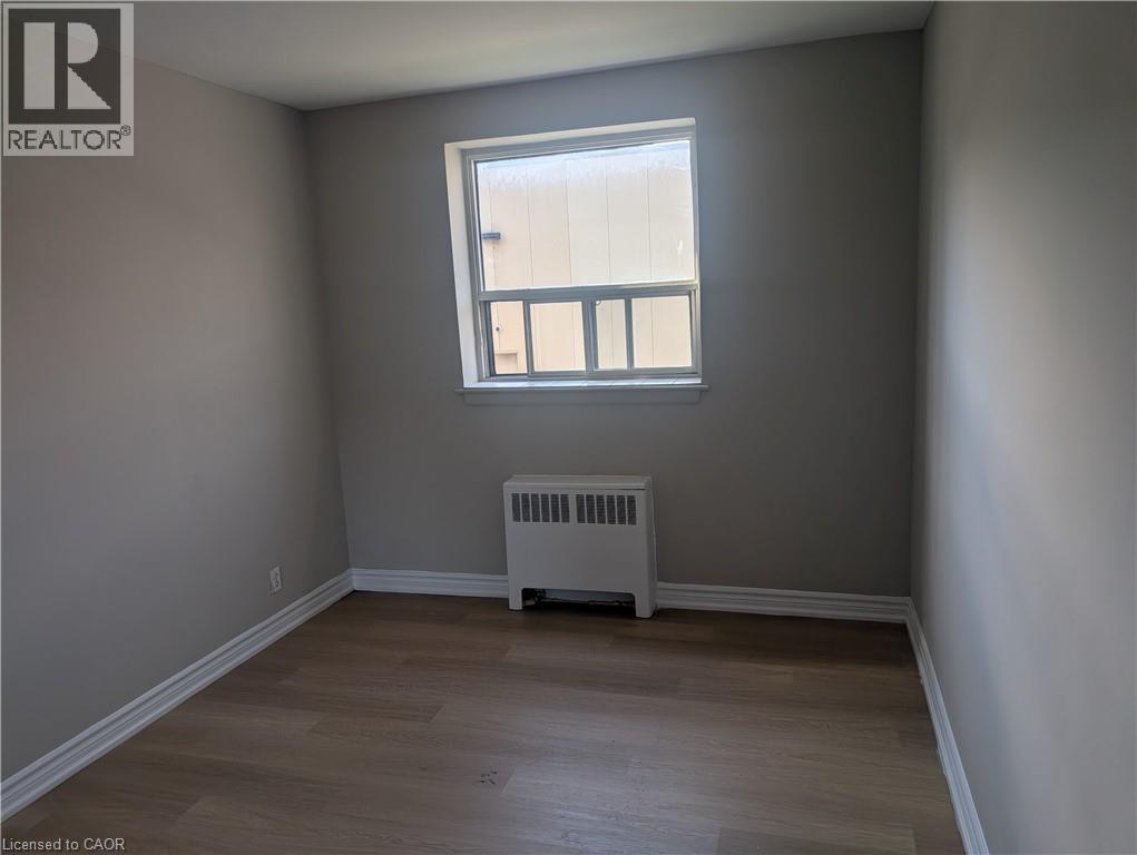 A room with a window and a radiator on the floor.