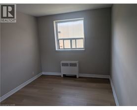 A room with a window and a radiator on the floor.
