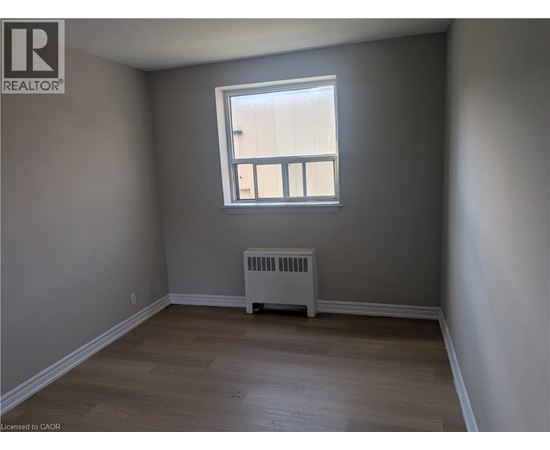 A room with a window and a radiator on the floor.