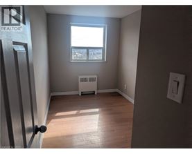 A room with a window and a radiator on the floor.