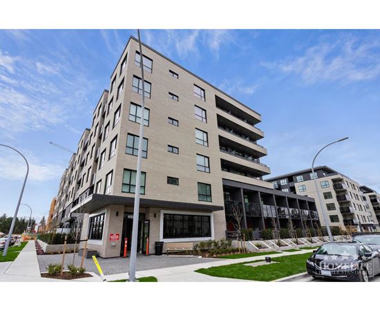A modern apartment building with a parking lot in front.