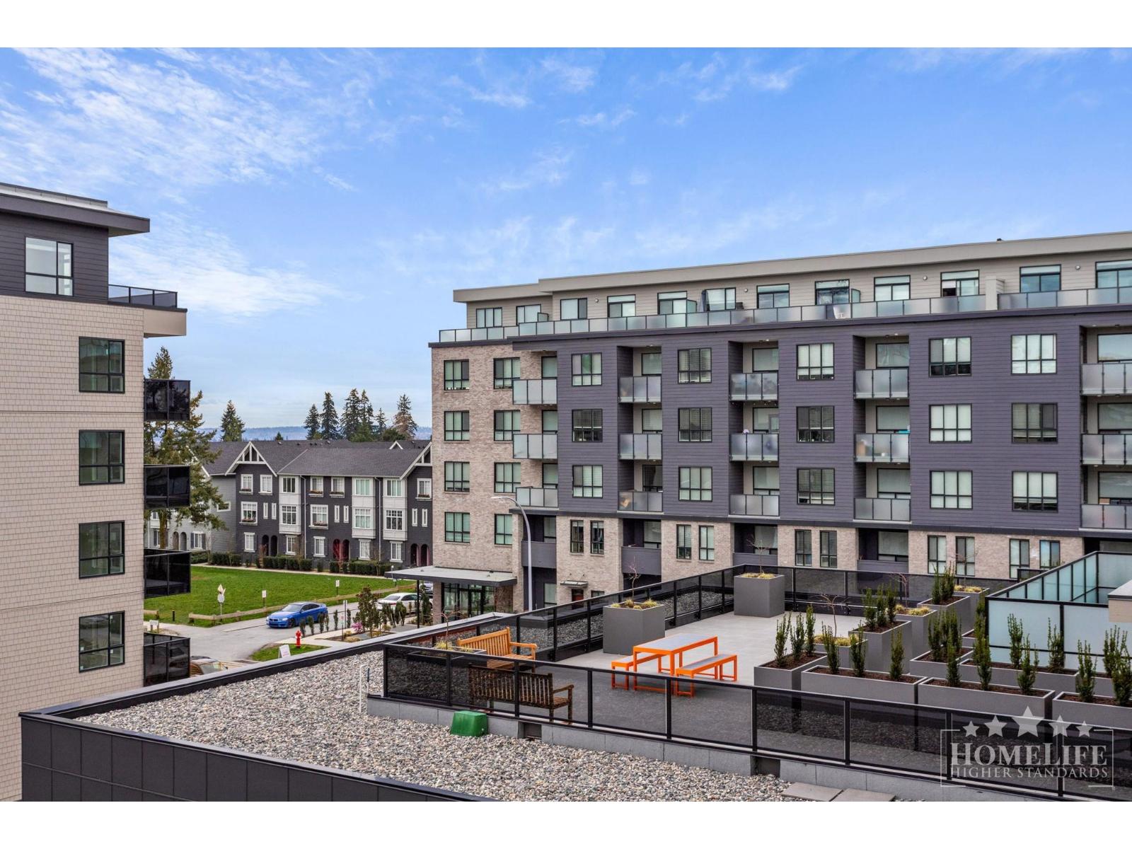 A modern apartment complex with a playground in the courtyard.
